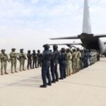 members of Mexico's military lined up and preparing to transfer criminals to the United States by airplane