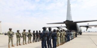 members of Mexico's military lined up and preparing to transfer criminals to the United States by airplane