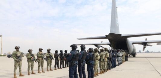 members of Mexico's military lined up and preparing to transfer criminals to the United States by airplane