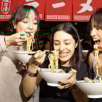 Three women eating noodles
