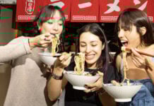 Three women eating noodles