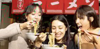 Three women eating noodles