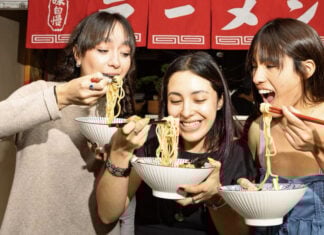 Three women eating noodles