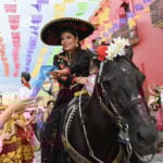 A woman riding a black horse