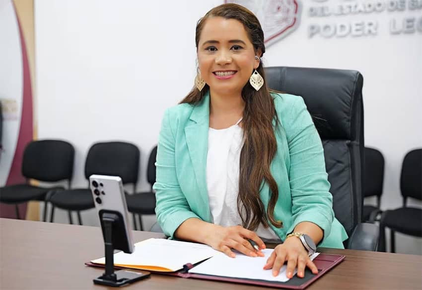 A woman in a mint green blazer sits at a table