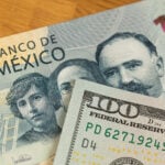 A 100 dollar bill and a 100 Mexican peso bill.