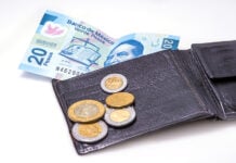 Mexican peso bills and coins with a wallet