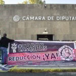 Activists hand a banner reading "#YoPorLas40Horas Reducción Ya!" outside the Mexican Chamber of Deputies