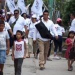 A security guard carrying a covered long gun at a political event