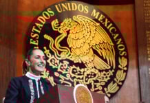 President Sheinbaum in front of a large seal reading Estados Unidos Mexicanos