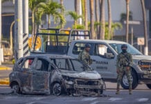 Mexican marines inspect a burned car in Puerto Vallarta