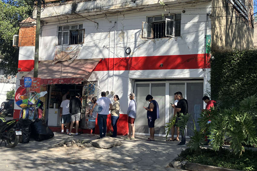 People standing in line out the door at a small corner store in Guadalajara, Mexico