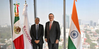 Mexico’s Economy Minister Marcelo Ebrard and India’s Ambassador to Mexico Panka Sharma pose with Mexican and Indian flags