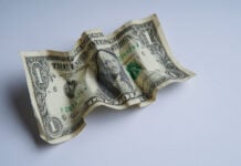 Financial crisis, crumpled one dollar banknote, US dollars on the white table. Bank image and commercial photo background.