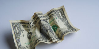 Financial crisis, crumpled one dollar banknote, US dollars on the white table. Bank image and commercial photo background.