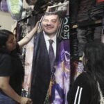 Girls look at a flannel blanket with Harfuch's face on it