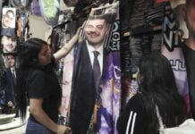 Girls look at a flannel blanket with Harfuch's face on it