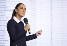 President Sheinbaum speaks into a microphone at a press conference