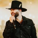 Carín León singing into a mic