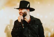 Carín León singing into a mic