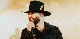 Carín León singing into a mic