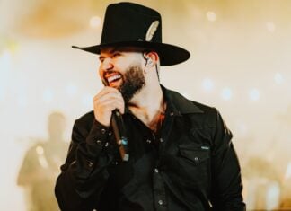 Carín León singing into a mic