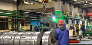 Chinese mill workers prepare hot-rolled steel coils.