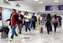 Passengers walk through a terminal at Mexico City International Airport