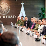Mexican security officials meeting with FIFA representatives at a long meeting table showing the Mexican seal with the word "seguridad"