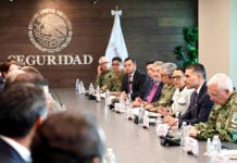 Mexican security officials meeting with FIFA representatives at a long meeting table showing the Mexican seal with the word "seguridad"