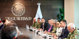 Mexican security officials meeting with FIFA representatives at a long meeting table showing the Mexican seal with the word "seguridad"