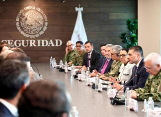 Mexican security officials meeting with FIFA representatives at a long meeting table showing the Mexican seal with the word "seguridad"