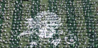 an aerial shot of hundreds of soccer players on an artificial turf set up in Mexico City's Zócalo
