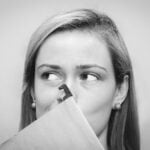 A woman holding her nose