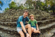 A dad and his middle schooler son take a selfie at a Maya pyramid in Mexico