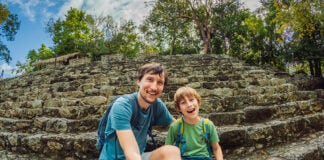A dad and his middle schooler son take a selfie at a Maya pyramid in Mexico
