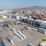 Container yard at the port of Manzanillo, showing stacked shipping containers, cargo trucks, and heavy equipment in operation. Manzanillo, Colima, Mexico, May 2, 2025.