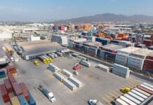 Container yard at the port of Manzanillo, showing stacked shipping containers, cargo trucks, and heavy equipment in operation. Manzanillo, Colima, Mexico, May 2, 2025.