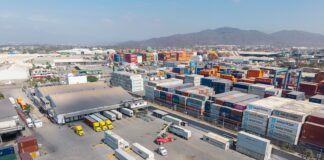 Container yard at the port of Manzanillo, showing stacked shipping containers, cargo trucks, and heavy equipment in operation. Manzanillo, Colima, Mexico, May 2, 2025.
