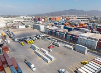 Container yard at the port of Manzanillo, showing stacked shipping containers, cargo trucks, and heavy equipment in operation. Manzanillo, Colima, Mexico, May 2, 2025.