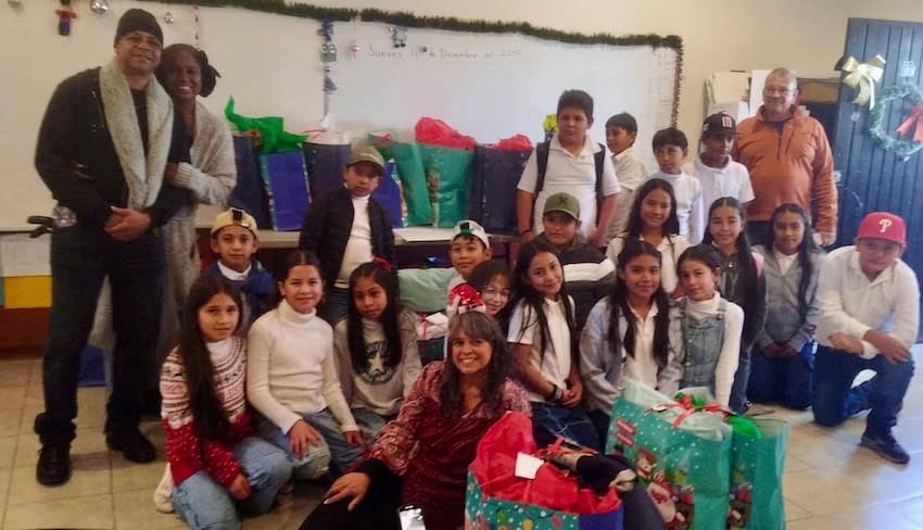 A group of volunteers handing out gifts to children