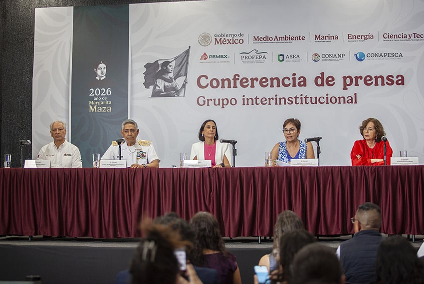 A group of government officials at a podium under the banner "Conferencia de prensa: Grupo interinstitucional"