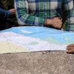 people standing around map of yucatán peninsula