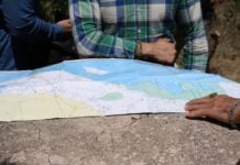 people standing around map of yucatán peninsula