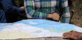 people standing around map of yucatán peninsula