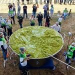 A giant vat of guacamole weighing 7.2 tonnes with volunteers scattered around it