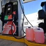Fuel cannisters next to a Pemex gas station pump