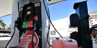 Fuel cannisters next to a Pemex gas station pump