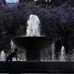 Children in silhouette playing on a bright day by a fountain in the historic center of Guadalajara, Mexico.