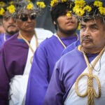 Nazarenes in purple robes and crowns of thorns and flowers walk in Mexico City